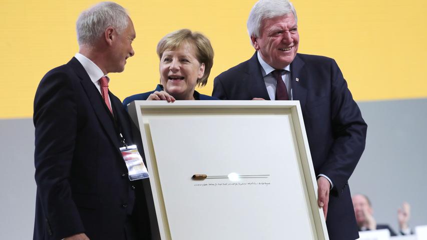 Ein Geschenk der anderen Sorte: Merkel bekam einen Dirigentenstab des Dirigenten Nagano geschenkt. Neben ihr stehen CDU-Bundesgeschäftsführer Klaus Schüler (links) und der Ministerpräsident von Hessen, Volker Bouffier.