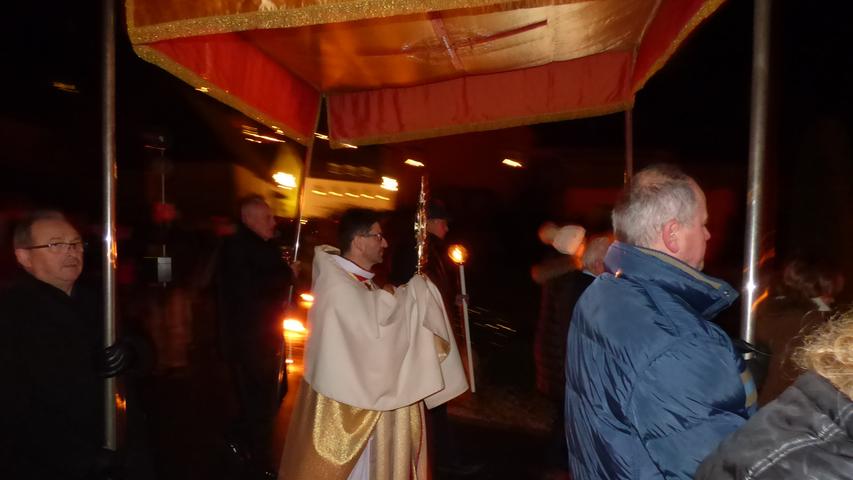 Pfarrer Pater Flavian Michali trug das Allerheiligste unter dem Baldachin durch den Pfarrort.