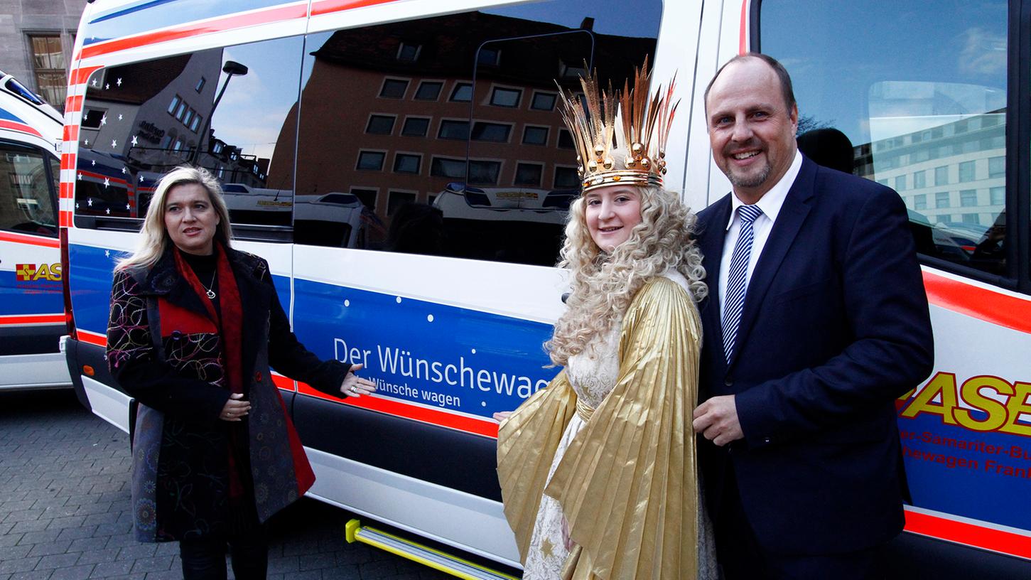 Bayerns Gesundheitsministerin Melanie Huml und Nürnbergs Bürgermeister Christian Vogel stellen gemeinsam mit Christkind Rebecca den neuen Wünschewagen des ASB vor.