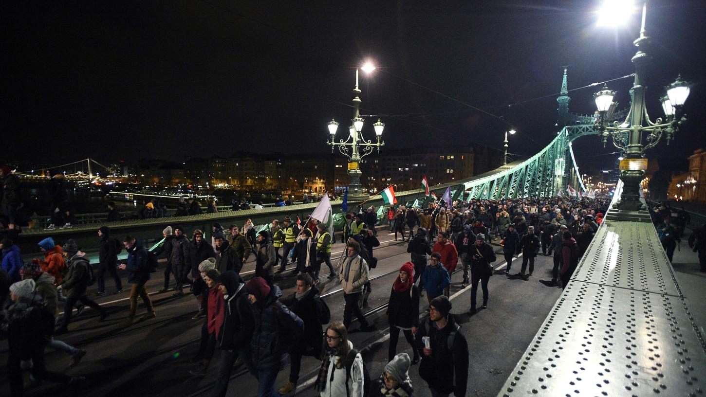 Teilnehmer des Demonstrationsmarsches gegen die Regierung gehen über die Szabadsag Brücke.