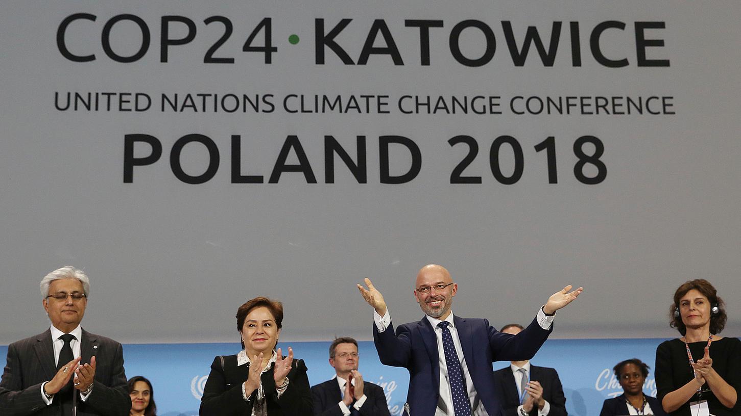 Michal Kurtyka (M), Präsident der UN-Klimakonferenz "COP24" , und weitere Teilnehmer des Klimagipfels freuen sich über den Beschluss des Kompromisses beim Weltklimagipfel.