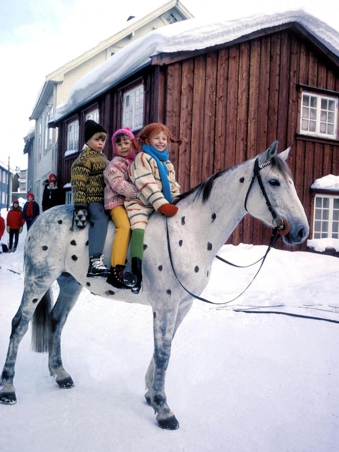 Inger Nilsson als Pippi Langstrumpf, reitet zusammen mit Pär Sundberg als Tommy und Maria Persson als Annika auf dem Pferd „Kleiner Onkel“ (Filmszene 1969).
