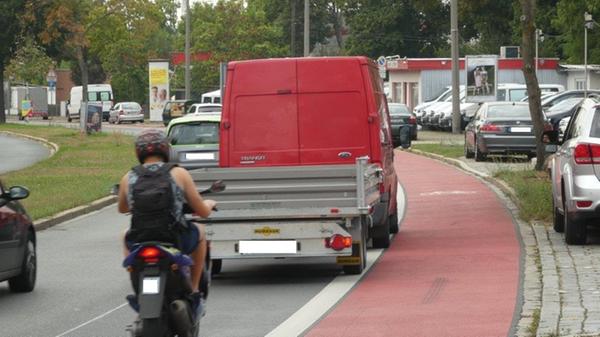 Wenn Fahrzeuge auf einer „überbreiten“ Spur wie hier in der Minervastraße nebeneinander fahren, obwohl der Platz hierfür nicht ausreicht, dann kommen sie den Radfahrern gefährlich nah. Die vorgeschriebenen 1,50 Meter Überholabstand werden so nicht eingehalten.