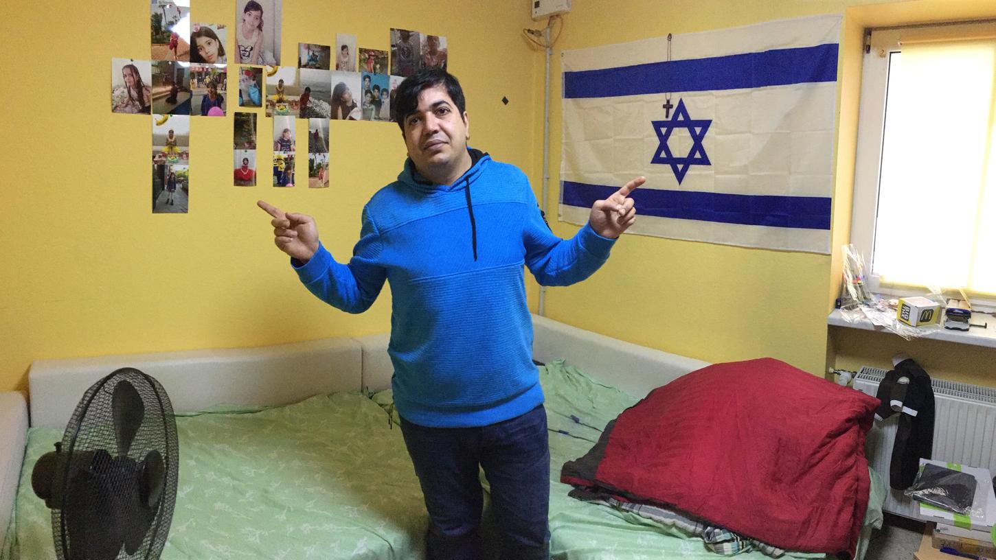 Jasem Nabhani in seinem Zimmer: An der Wand hängen viele Fotos seiner Tochter und seiner Frau. Doch auch eine israelische Fahne hat er angebracht. Er will damit ausdrücken, dass er zwar Iraner ist, aber nichts gegen Israelis oder Juden hat.
