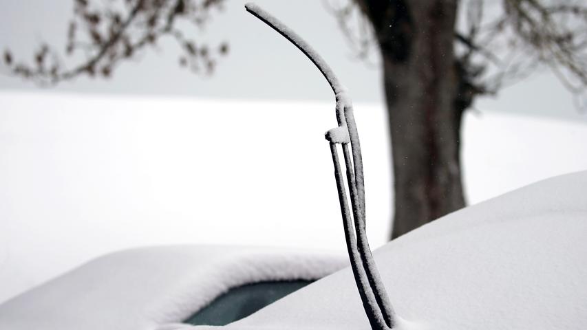Im allgäuischen Rückholz ragt der aufgestellte Scheibenwischer eines Autos aus dem Schnee.