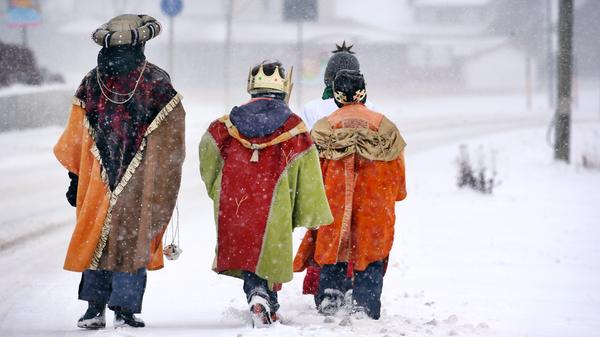 Lengenwanger Sternsinger kämpfen sich zu Fuß durch das dichte Schneetreiben. Ihre bunten Kostüme sind ein schöner Kontrast zur sonst weißen Umgebung.