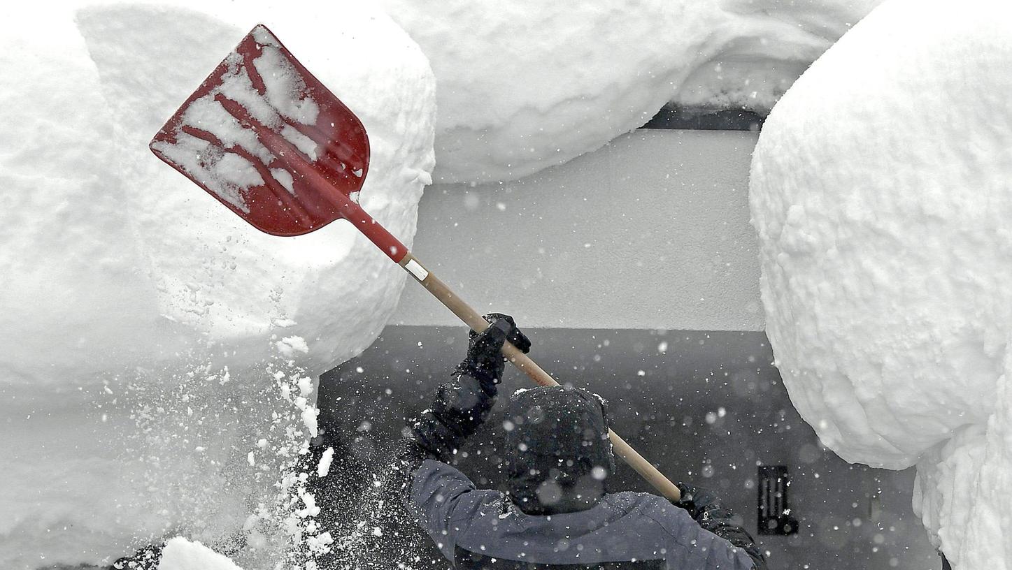 Runter mit der weißen Pracht: Ein Mann im österreichischen Ramsau befreit ein Hausdach von den Schneemassen, die sich dort in den vergangenen Tagen aufgetürmt haben.