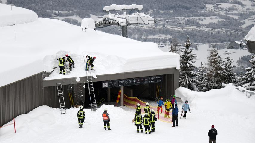 In Schönau am Königssee räumen Feuerwehrleute den Schnee vom Dach einer Ski-Liftstation der Jennerbahn.