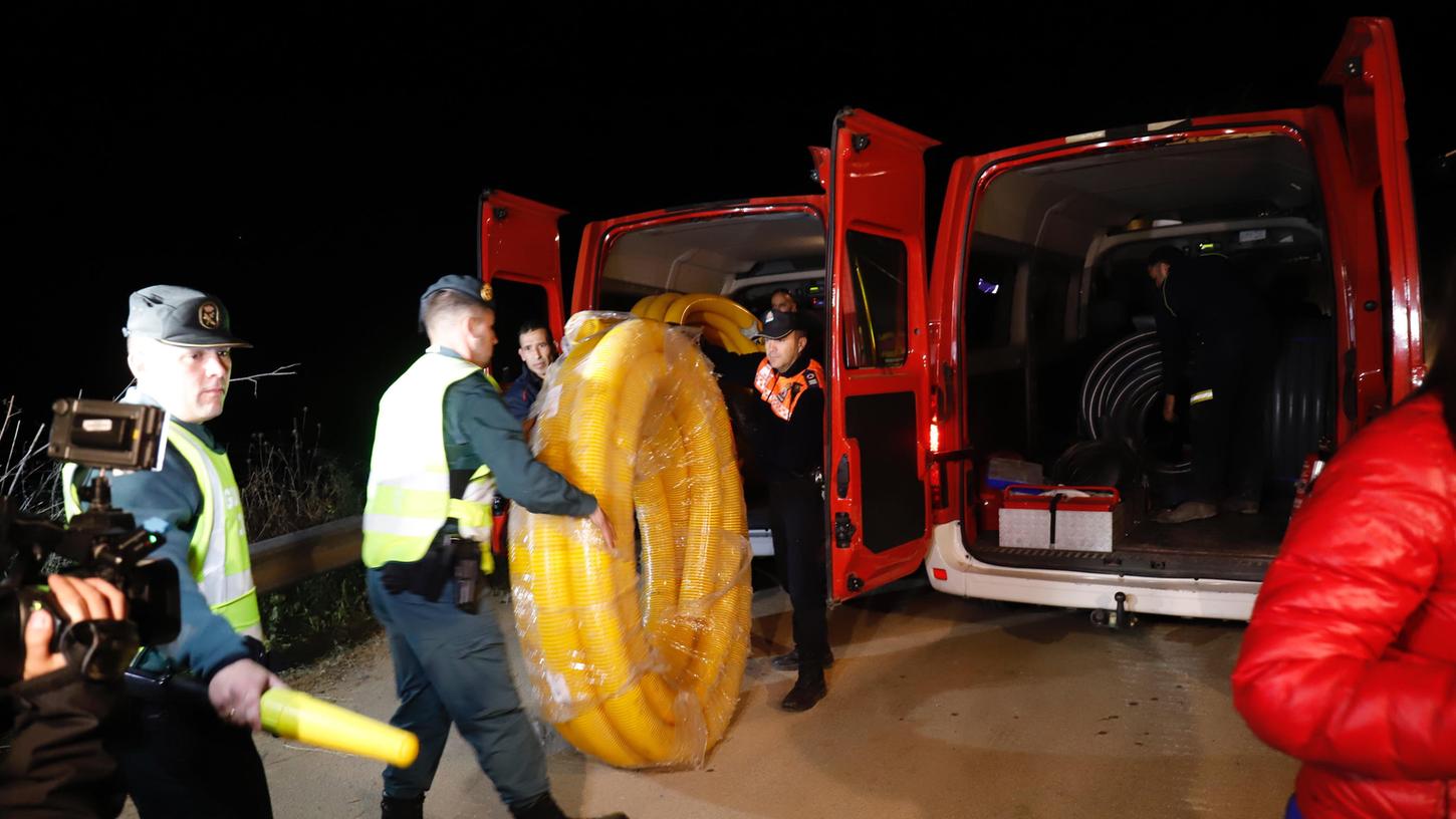 Spanien, Totalán: Einsatzkräfte tragen Rohre zu einem 110 Meter tiefen Brunnenschacht. Die Einsatzkräfte arbeiten auch in der Nacht.