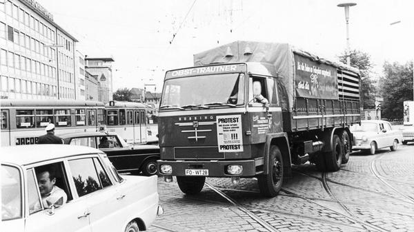 Obstbauern aus der Fränkischen Schweiz um Forchheim und Pretzfeld demonstrierten 1969 mit einem Konvoi durch Erlangen und Nürnberg gegen ein Fahrverbot. Hier kamen die Protestierer über den Rathenauplatz in Nürnberg. Mittig im Bild: Ein schwerer Pritschen-Lkw der Braunschweiger Marke Büssing. Mehr Bilder von den "Großen Sieben" Nutzfahrzeugherstellern aus Deutschland, zu denen neben Büssing auch FAUN und Henschel gehörten, finden Sie hier. Außerdem bereichern zwei "Heckflossen" von Mercedes-Benz dieses Bild.