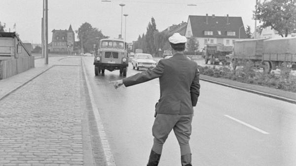 Nicht nur Autofahrer wurden schon in den 1960er-Jahren von der Polizei kontrolliert: Hier winkt ein Polizist einen Eckhauben-Lkw der Marke Magirus-Deutz an den Straßenrand.