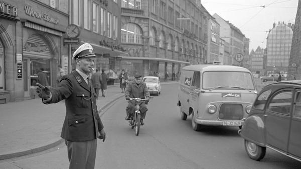 Nicht nur Nürnberger Polizisten taten in der Noris Dienst: Wie dieses Foto von 1966 zeigt, halfen in Nürnberg auch Beamte aus Berlin aus, hier in der Karolinenstraße. Rechts im Bild: Die erste Generation des Ford Transit hinter einem Citroën 2CV, besser bekannt unter dem Kosenamen "Ente". Eine Galerie mit den kultigsten Oldtimern finden Sie hier.
