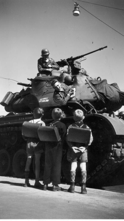 Ein amerikanischer Panzer rollt an: Die einheimischen Kinder erkennen schnell, dass die Amerikaner nicht so bedrohlich sind, wie sie die Nationalsozialisten darstellten.