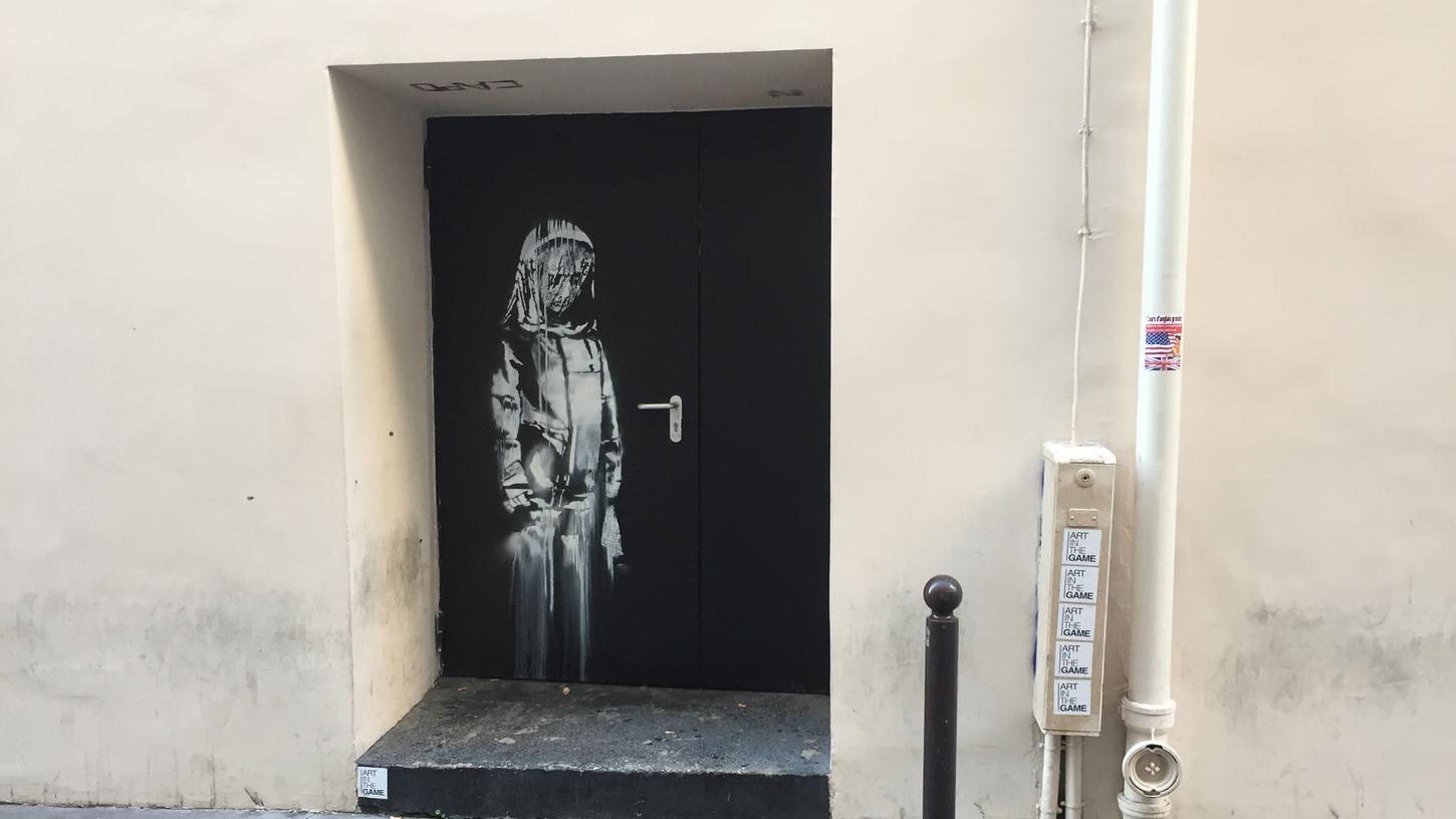 Auf einer Tür beim Pariser Musikclub "Bataclan" ist das Wandbild zu sehen, das dem britischen Street-Art-Künstler Banksy zugerechnet wird.