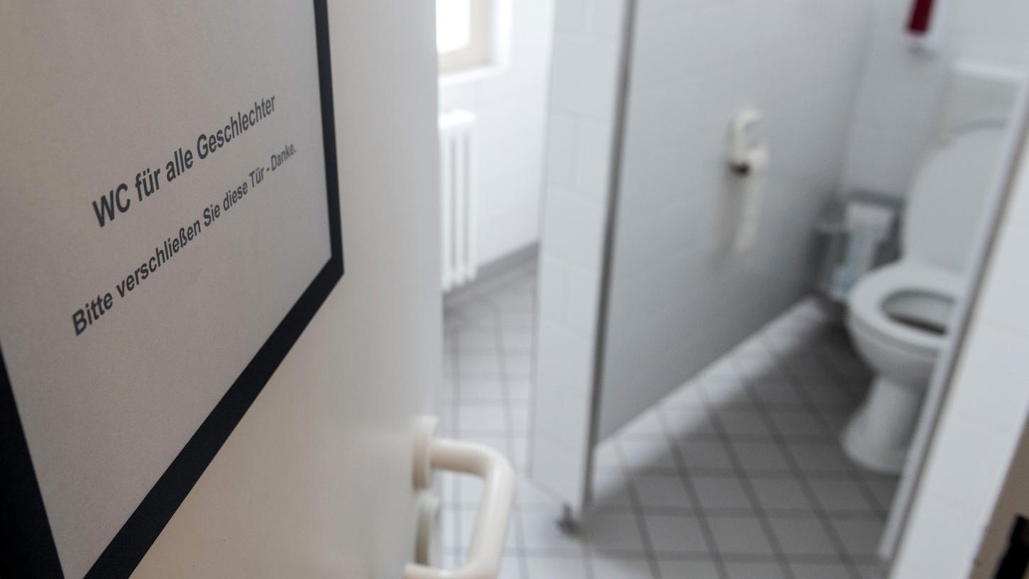 Ein Schild "WC für alle Geschlechter" hängt an der Tür zu einer ehemaligen Damentoilette.