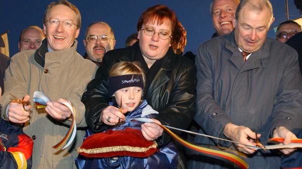 Ende 2002 konnte der Verkehr auf der A73 nahe Coburg freigegeben werden. Zu diesem Anlass kamen Bayerns Umweltminister Werner Schnappauf (l.), Iris Gleicke, Staatssekretärin des Bundesverkehrsministeriums, sowie Bayerns Innenminister Günther Beckstein. Das 12,3 Kilometer lange Teilstück war binnen zwei Jahren entstanden. Die Kosten hierfür beliefen sich auf 66 Millionen Euro.