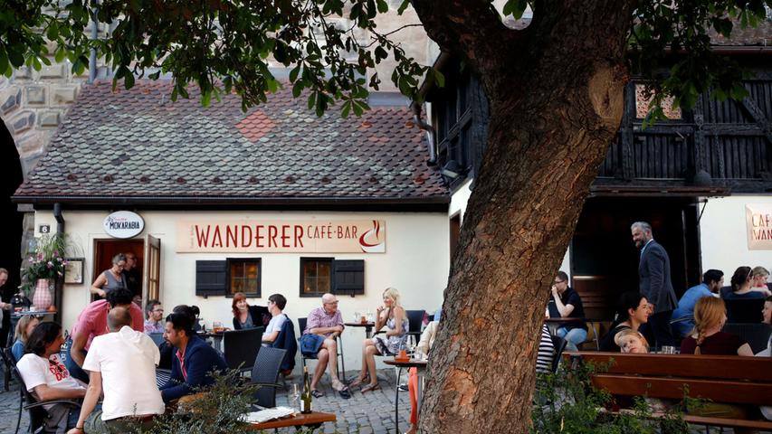Das Café Wanderer ist DER In-Treffpunkt Nürnbergs. Wer keinen Sitzplatz ergattert, macht es sich mit seinem Getränk einfach auf dem von der Sonne aufgewärmten Kopfsteinpflaster am Tiergärtnertor bequem und genießt den Sommer.