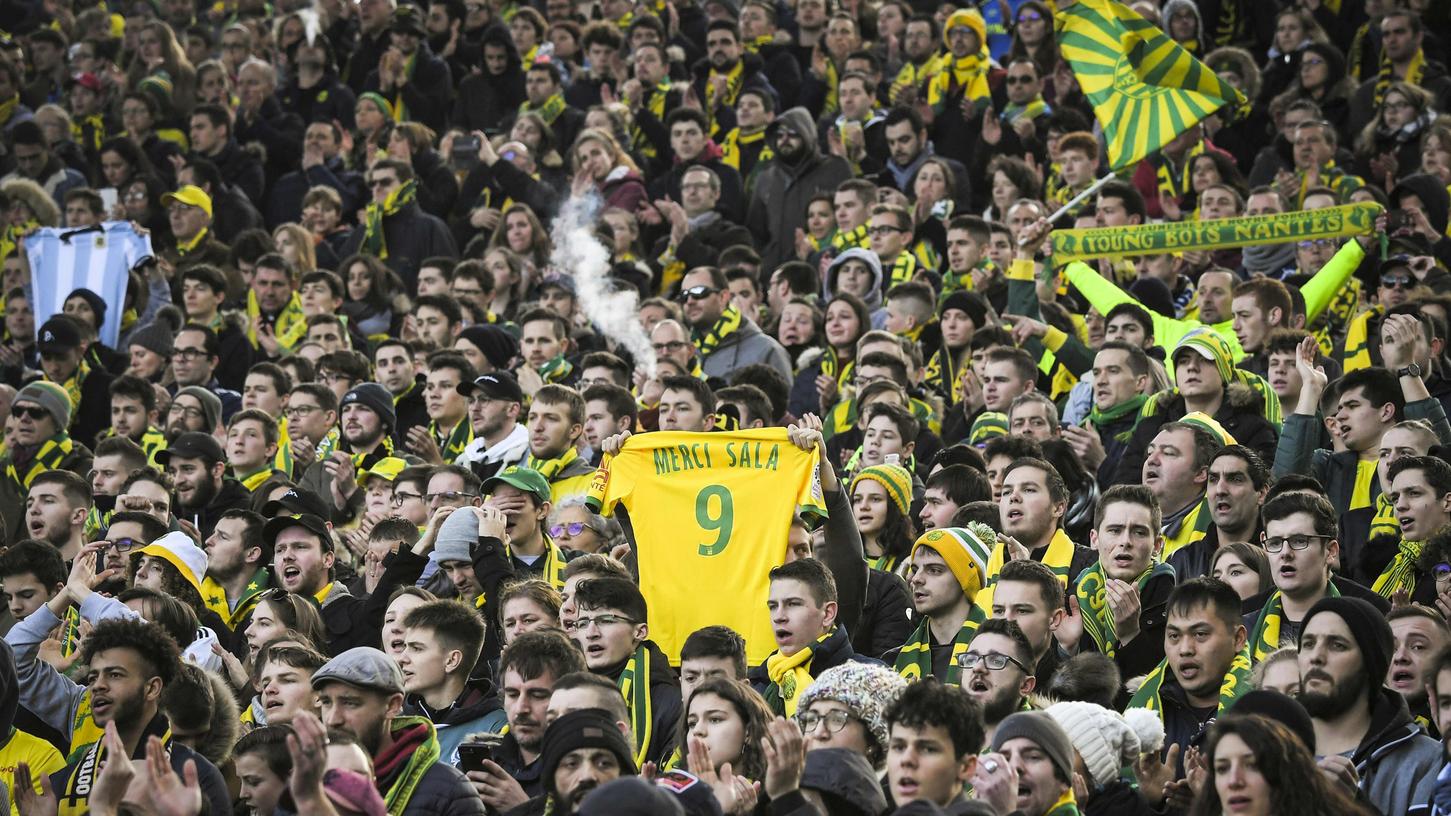 Ein Fan vom FC Nantes hält ein Trikot in die Höhe, auf dem er sich bei Emiliano Sala bedankt.