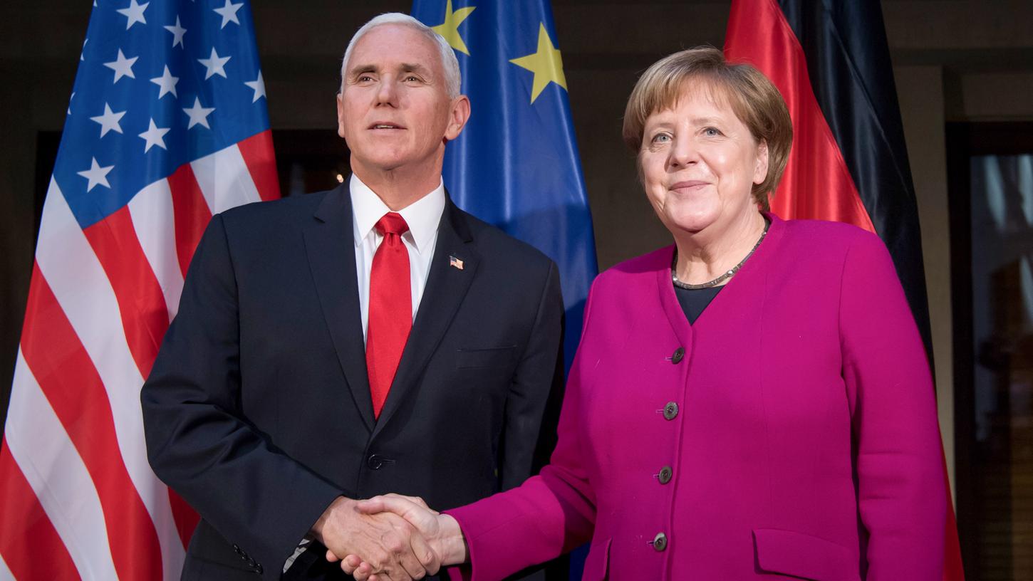 Bundeskanzlerin Angela Merkel (CDU) und Mike Pence, Vizepräsident der USA, begrüßen sich am zweiten Tag der Münchner Sicherheitskonferenz. Die Stimmung ist verhalten.