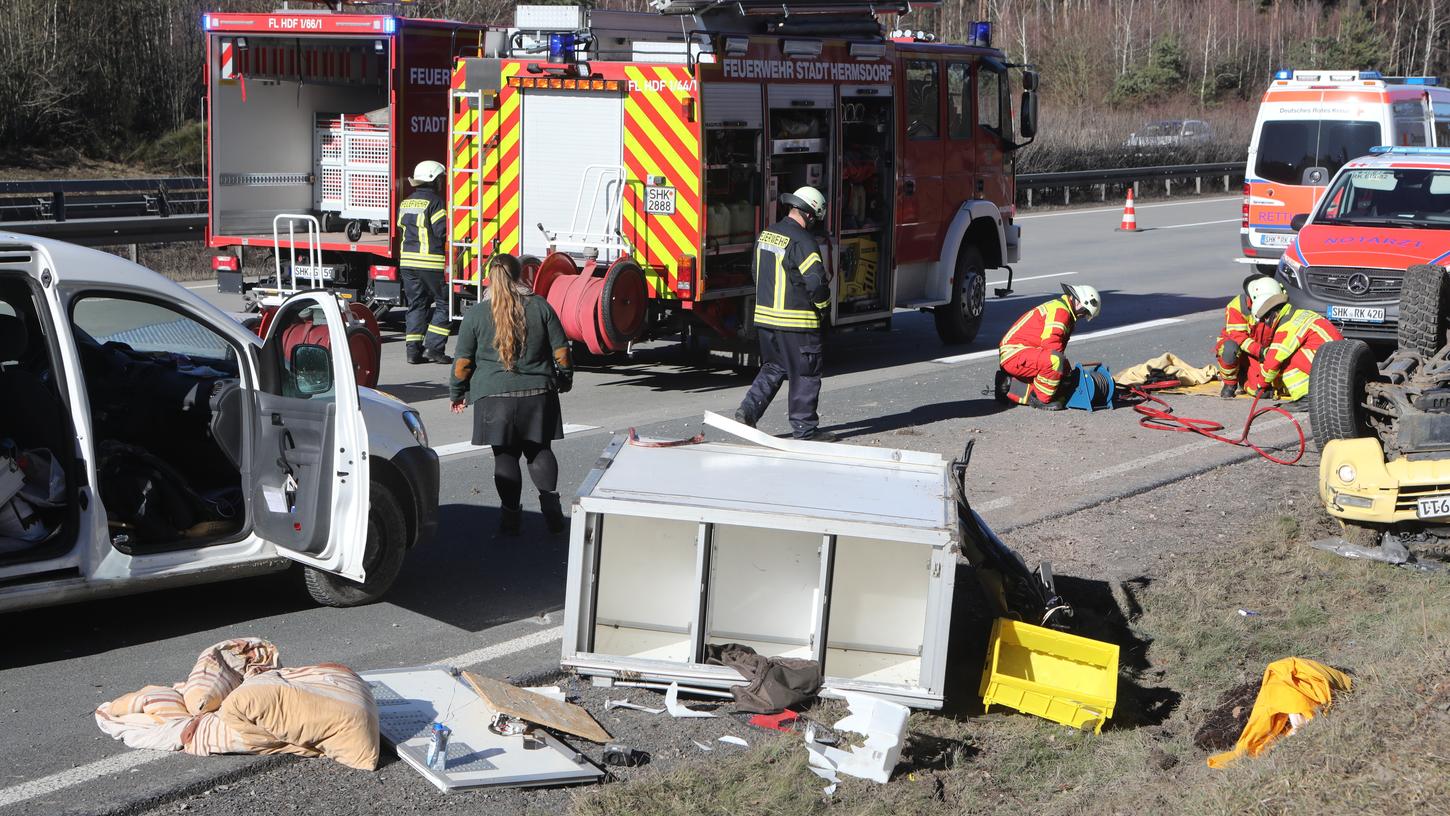 Rettungskräfte stehen an dem verunfallten Auto der Rettungshundestaffel Ostthüringen des ASB auf der Autobahn 9 bei Hermsdorf.