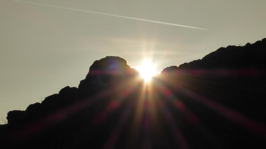 Die Sonne spitzt zwischen den Walberla-Felsen hindurch.