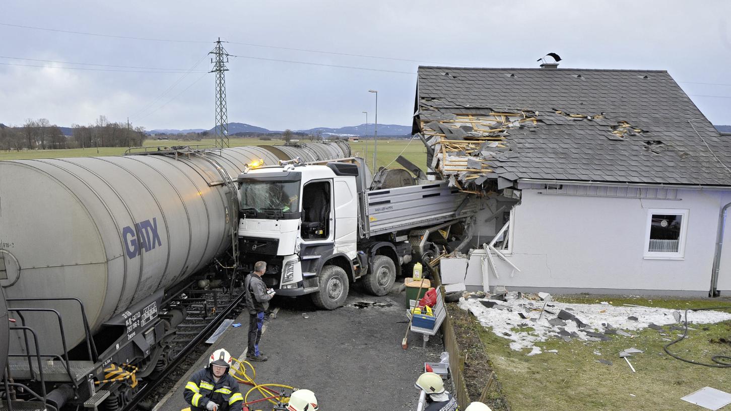 Hilfskräfte arbeiteten am Unfallort zwischen einem Zug mit Kesselwagen und einem Lkw in Achenlohe nahe Munderfing.