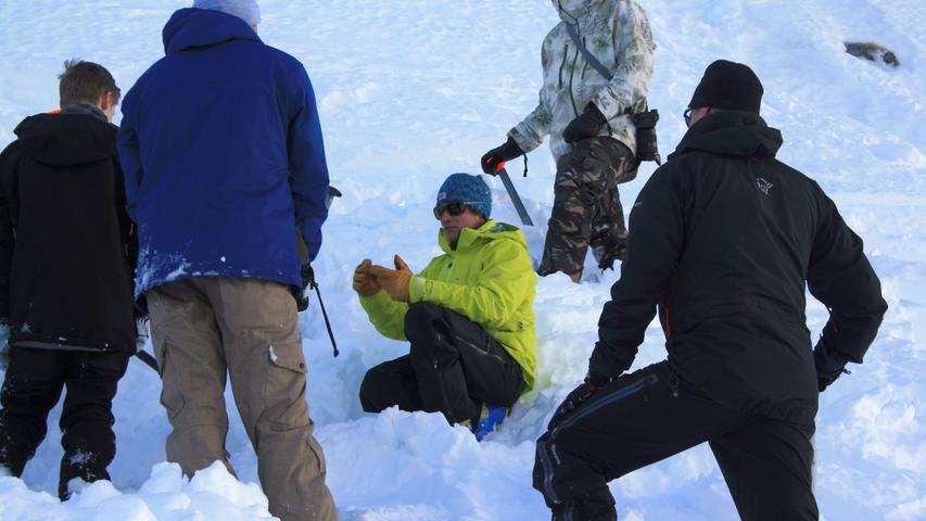 Dann geht es zum Üben ins Gelände: Nico erklärt, wie die Helfer im Ernstfall einen Verschütteten im Schnee finden können.