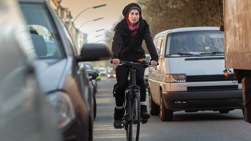 Gefährdete Radlerin: Wenn der Autofahrer jetzt die Tür öffnet, kann das üble Folgen haben. Gefährdete Radlerin: Wenn der Autofahrer jetzt die Tür öffnet, kann das üble Folgen haben.