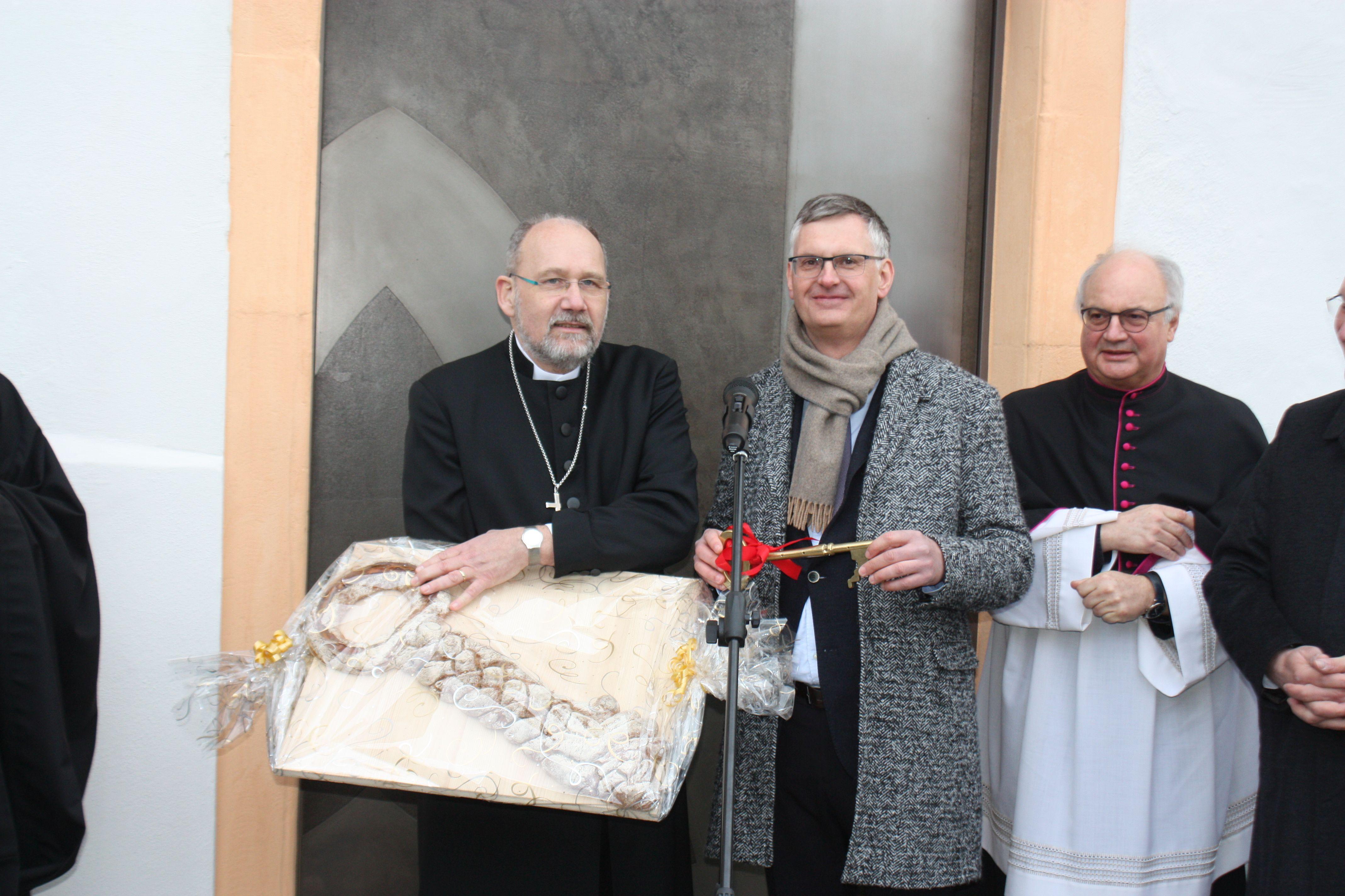 Noch ist die Klosterpforte geschlossen, doch Architekt Hans-Heinrich Häffner aus Ellingen hat für Hausherrn Dekan Klaus Kuhn den Schlüssel dabei. Neben einem Exemplar aus Metall überreichte er auch einen aus Brotteig gebackenen Schlüssel samt dem obligatorischen Salz.