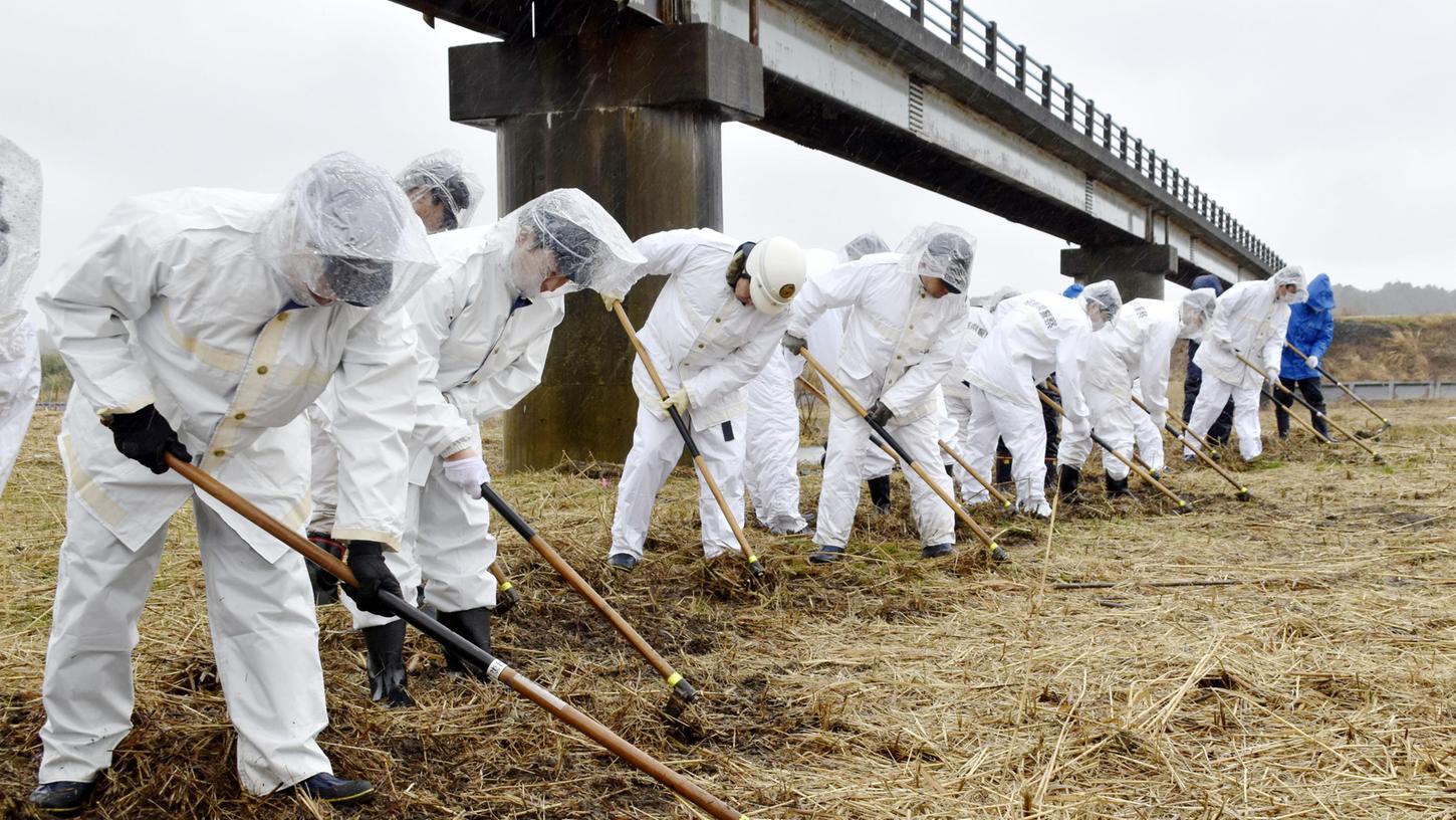 Aus dem Archiv: Polizeibeamte suchen an einem Flussufer in Namie, Präfektur Fukushima, nach den Überresten von Menschen, die beim schweren Erdbeben und Tsunami 2011 im Nordosten Japans vor genau acht Jahren verschollen sind.