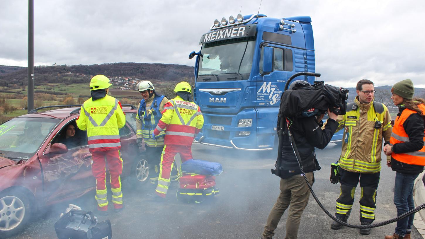 RTL-Reporterin Verena Jendges (re.) spielte bei einem fiktiven Unfall Ersthelferin. Feuerwehr und Rettungsdienst sind schon eingetroffen. Kommandant Sebastian Müller (2. v. r.) bespricht mit ihr, was besser gemacht werden kann.