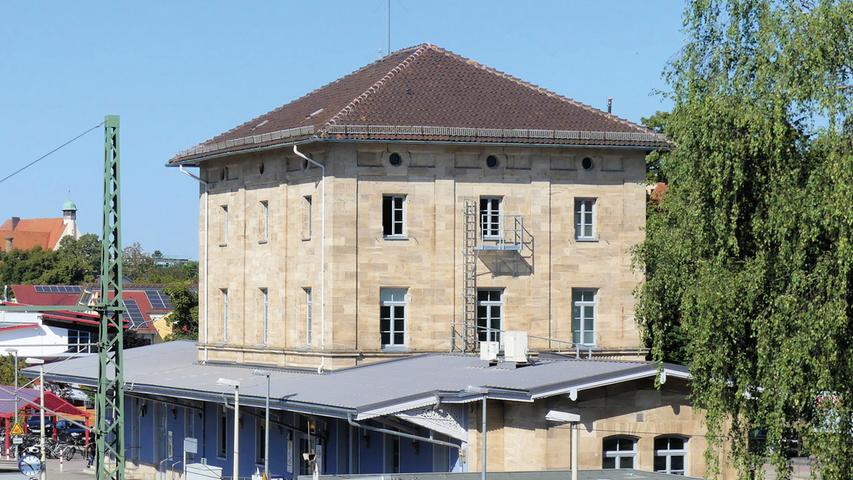 Es waren ortsansässige Fabrikanten, die im 19. Jahrhundert die dringend notwendige Eisenbahnanbindung Weißenburgs an die Zweigbahn, die von Pleinfeld über Treuchtlingen nach Ingolstadt fuhr, bewirkten. 1869 erhielt die Stadt, die sich selbst sehr für die Einrichtung eines eigenen Bahnhofes einsetzte, ihr Empfangsgebäude. Der mehrgeschossige Mitteltrakt mit drei zu drei Fensterachsen und flachen Seitenflügeln folgte dabei der Grundform damaliger Bahnhöfe. Als Sandsteinbau mit Lisenengliederung zeigt der dreigeschossige Walmdachbau mit eingeschossigen Seitenflügeln darüber hinaus eine anspruchsvolle Gestaltung. Zwar hatte der Durchgangsbahnhof gegenüber Bahnhöfen mit Umstiegmöglichkeiten eine geringere verkehrstechnische Bedeutung. Dennoch sollte er dem Stellenwert der Stadt Rechnung tragen. Es waren ortsansässige Fabrikanten, die im 19. Jahrhundert die dringend notwendige Eisenbahnanbindung Weißenburgs an die Zweigbahn, die von Pleinfeld über Treuchtlingen nach Ingolstadt fuhr, bewirkten. 1869 erhielt die Stadt, die sich selbst sehr für die Einrichtung eines eigenen Bahnhofes einsetzte, ihr Empfangsgebäude. Der mehrgeschossige Mitteltrakt mit drei zu drei Fensterachsen und flachen Seitenflügeln folgte dabei der Grundform damaliger Bahnhöfe. Als Sandsteinbau mit Lisenengliederung zeigt der dreigeschossige Walmdachbau mit eingeschossigen Seitenflügeln darüber hinaus eine anspruchsvolle Gestaltung. Zwar hatte der Durchgangsbahnhof gegenüber Bahnhöfen mit Umstiegmöglichkeiten eine geringere verkehrstechnische Bedeutung. Dennoch sollte er dem Stellenwert der Stadt Rechnung tragen.