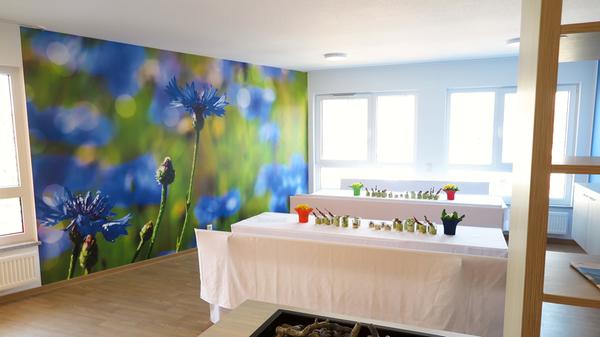 Die vier Hausgemeinschaften des neuen Treuchtlinger BRK-Pflegeheims sind nach Blumen benannt und farblich gestaltet – hier der Aufenthaltsraum der Gruppe „Kornblume“ (blau).