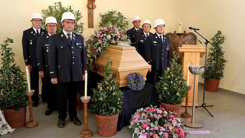 Die Männer der Ehrenwache der Freiwilligen Feuerwehr Forchheim stehen deutlich ergriffen neben dem Sarg mit den sterblichen Überresten des Alt-OB.