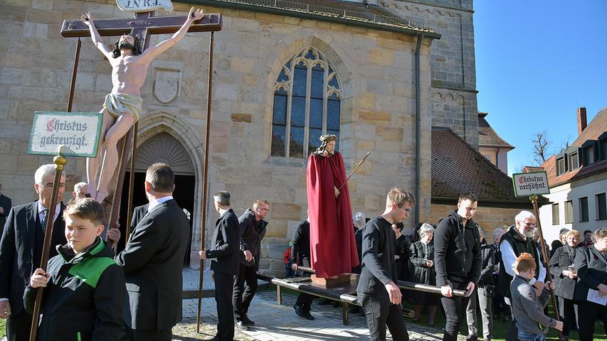 Elf Figuren werden von Männern und Jugendlichen aus allen Gemeindeteilen durch den Ortskern von Neunkirchen getragen.