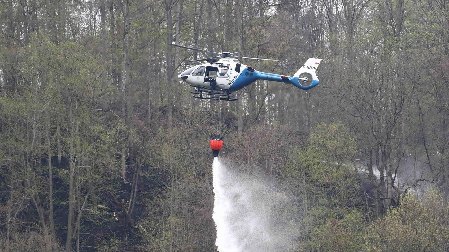 Ein Polizeihubschrauber hilft mit, einen Brand im Wald an der Bleilochtalsperre in Thüringen zu löschen. Neben Feuerwehrkräften aus dem Saale-Orla-Kreis sind auch Rettungskräfte und Technisches Hilfswerk aus Oberfranken im Einsatz.