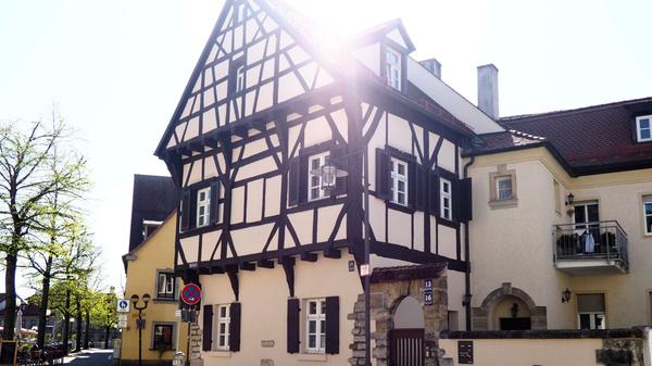 Das Haus am Marktplatz 16 wurde 1392 errichtet - mit einem oberen, vorragenden Stockwerk. 1619 taucht es in Unterlagen als „das hohe Hauß“ auf. Der Forchheimer Maler Michael Kotz hielt das Wohnhaus um 1900 in einer aquarellierten Federzeichnung fest. Bis heute hat der zweistöckige Fachwerkbau seinen Stammplatz als Eckhaus an der Burgerhofstraße behalten.