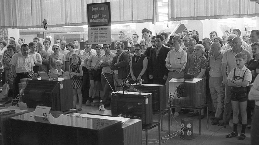 Die Kundinnen und Kunden in der Fernsehabteilung eines Nürnberger Kaufhauses verfolgten gespannt den Start des Raumschiffes Apollo 11, das die drei amerikanischen Astronauten samt ihrer Mondfähre pünktlich auf die Minute ins All hinausträgt.