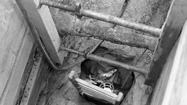 So sieht die Baustelle in der Bauvereinstraße aus: durch ein schmales Loch klettert der Arbeiter (rechts) in den unterirdischen Tunnel, der 2,50 Meter hoch und etwa einen Meter breit ist, Der „Fluchtgang“ soll mehrere hundert Meter lang sein. Hier geht es zum Artikel vom 10. Mai 1969: Fluchtweg oder Wasserschacht?