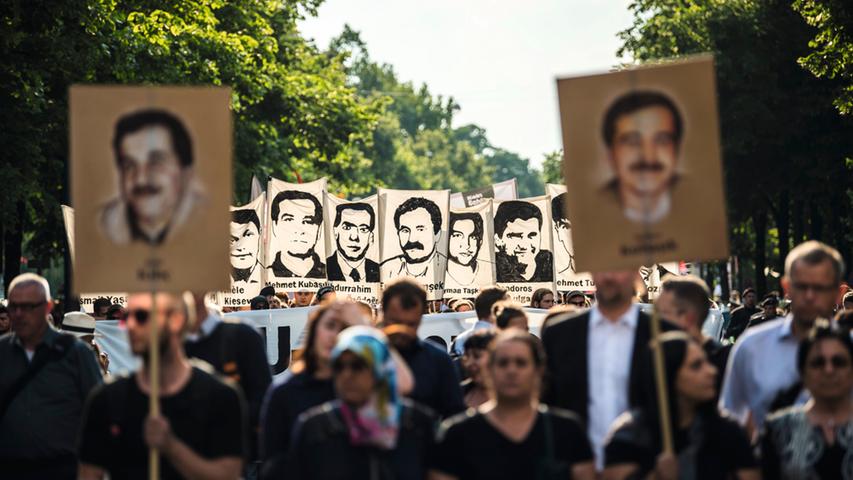 Demonstranten halten am 11. Juli 2018 in München die Porträts der NSU-Opfer in den Händen. Am Morgen dieses Tages war der Prozess gegen fünf mutmaßliche Mitglieder der rechtsextremen Terrorgruppe Nationalsozialistischer Untergrund mit Schuldsprüchen zu Ende gegangen. Die waren nach Ansicht der Opferfamilien zu milde ausgefallen.