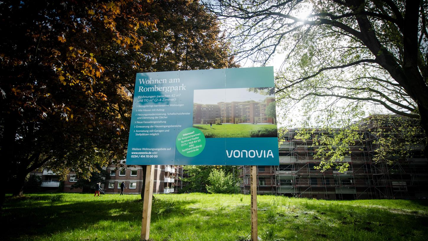 Ein Werbeschild weist vor einem eingerüsteten Wohnblock auf das Wohnungsangebot des Wohnungsbauunternehmens Vonovia hin.