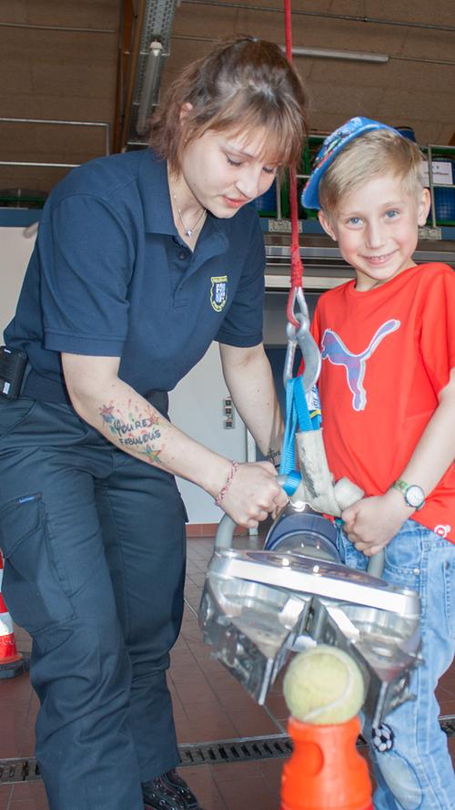 Feuerwehr-Jugendbetreuerin Isabelle lässt den siebenjährigen Leopold an einer Station der Familien-Stadt-Rallye am Spreizer mit tonnenschwerer Kraft spielen.