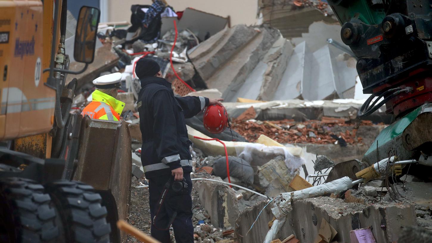 Ein Spurensicherer der Kriminalpolizei steht in den Trümmern eines explodierten Wohnhauses. Stunden nach der Explosion haben Helfer zwei Leichen geborgen.