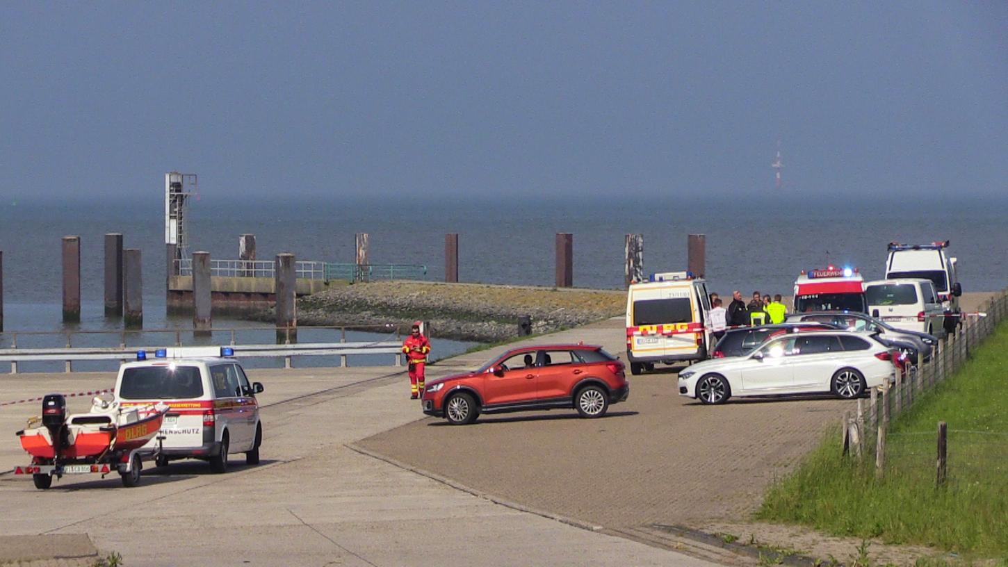 Helfer der Deutschen Lebens-Rettungs-Gesellschaft stehen bei einer Suchaktion auf einem Parkplatz neben der Nordsee.
