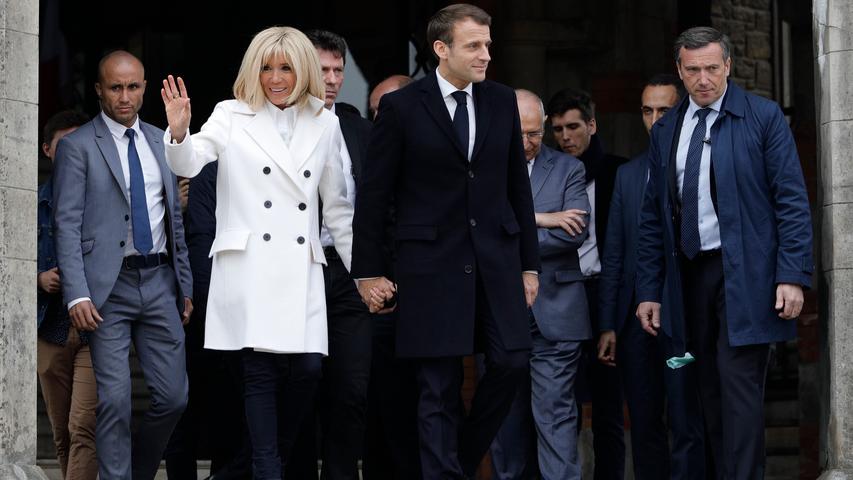 Auch sie haben ihr Kreuz schon gesetzt: Emmanuel Macron (Mitte), Präsident von Frankreich, und seine Frau Brigitte (links) verlassen nach der Stimmabgabe ein Wahllokal.