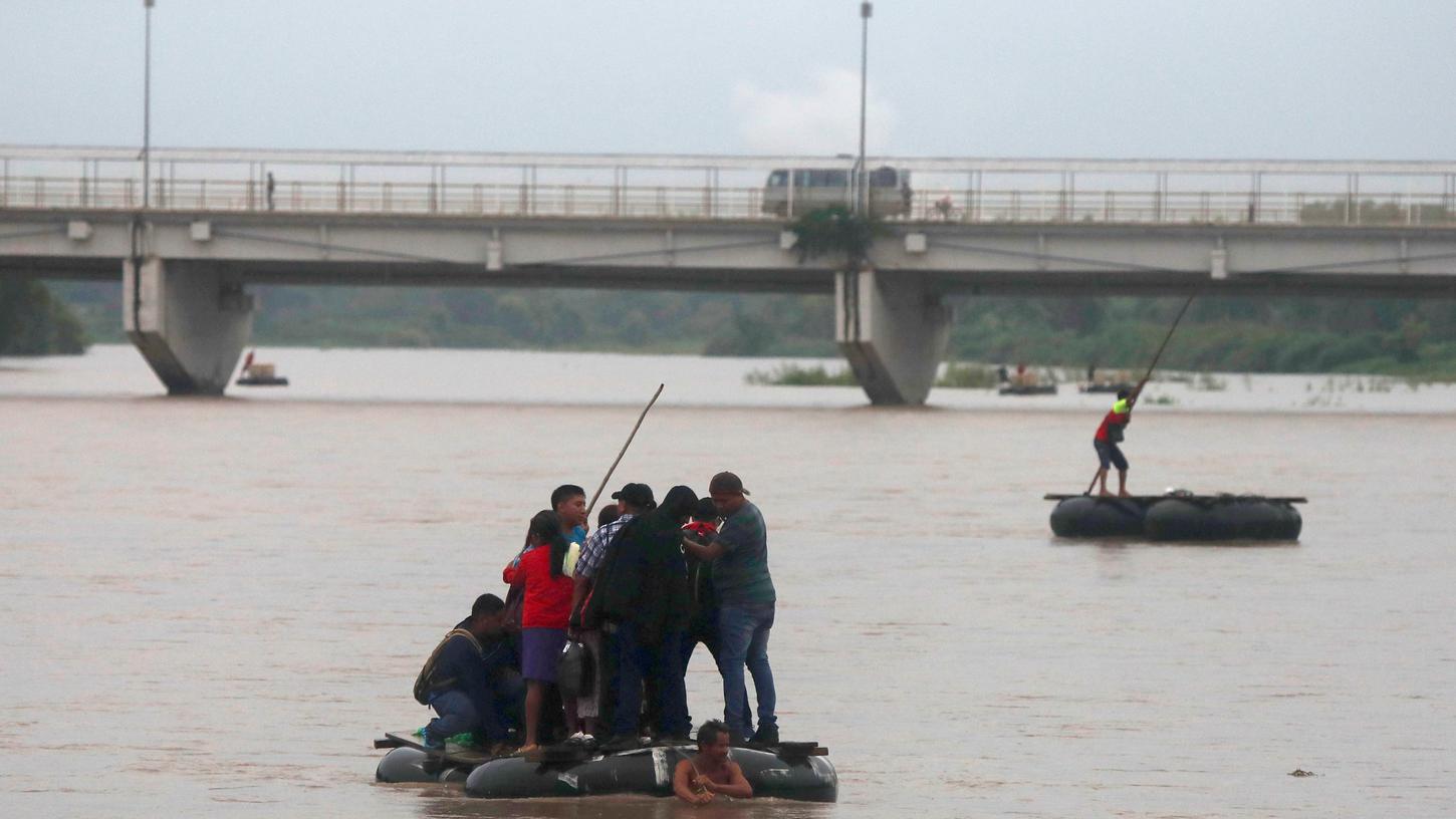 Migranten überqueren mit einem Floß den Fluss Suchiate an der Grenze Guatemala - Mexiko, nahe der Stadt Ciudad Hidalgo.