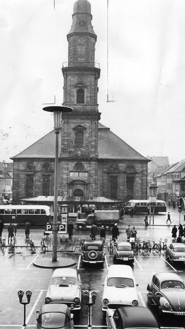 1957 sah der Hugenottenplatz in Erlangen noch völlig anders aus als heute. Damals gab es auch noch keine Fußgängerzone in der Stadt. Diese wurde erst im Dezember 1973 eingeführt, als zunächst an Samstagen die Hauptstraße für Fahrzeuge gesperrt wurde. Am 22. Mai 1976 wurden der Ostteil des Hugenottenplatzes und die Untere Karlstraße zur Fußgängerzone erklärt.
