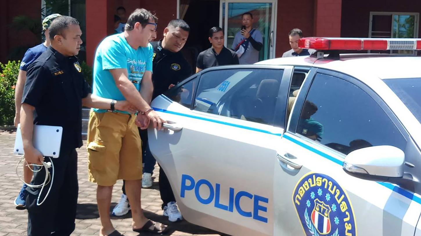 Das von der Crime Suppression Division of Thailand zur Verfügung gestellte Foto zeigt Francesco Galdeli (blaues Shirt) aus Italien, der von thailändischen Polizisten zu einem Polizeiauto geführt wird.