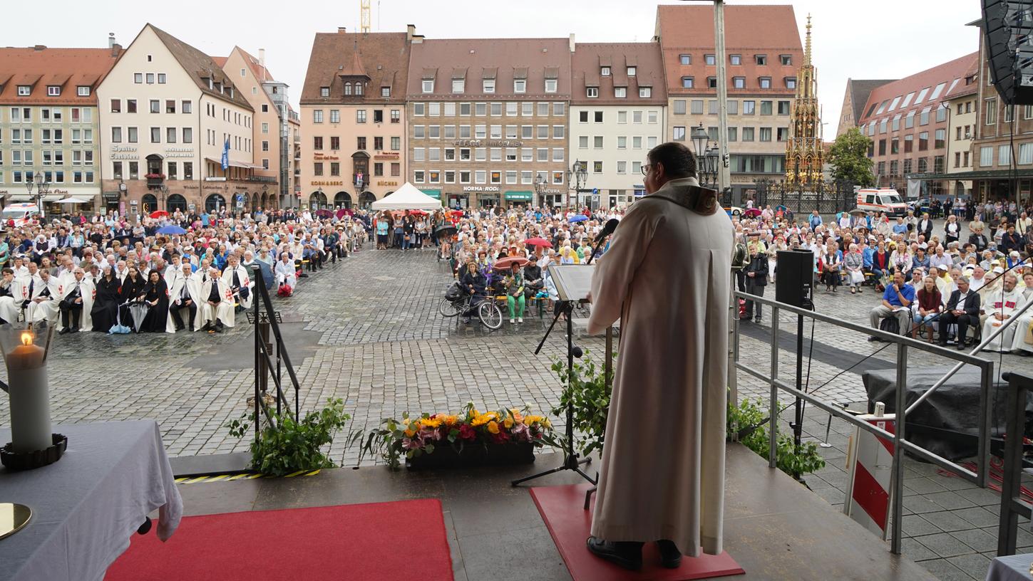 In Nürnberg ziehen Pfarrer, Diakone, Ministranten, Verbände und Ritterorden über den Hauptmarkt zurück zur Frauenkirche.
