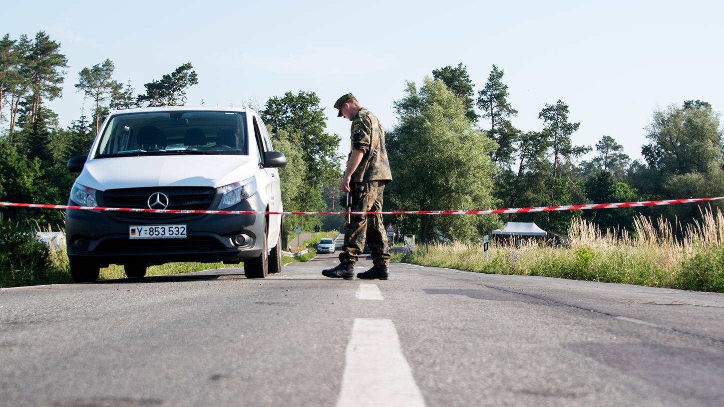 Nossentin: Ein Soldat steht an einer Straßensperre nahe eines Waldgebietes. Die Ermittlungen zur Ursache des Absturzes laufen noch.